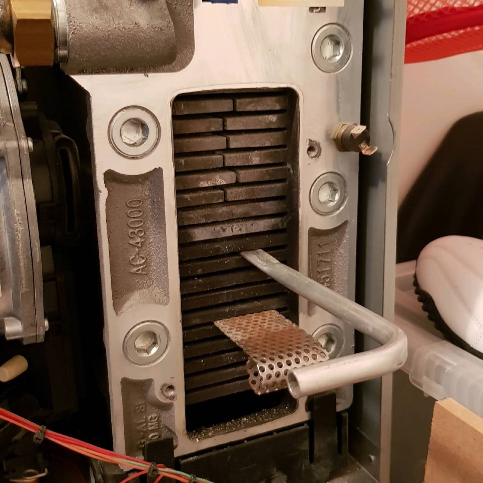 Inside an older appliance during a strip-down — the combustion side, where a proper service earns its money.